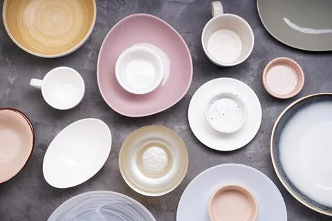 Ceramic and wooden small tableware on gray background, top view. Stock Photos