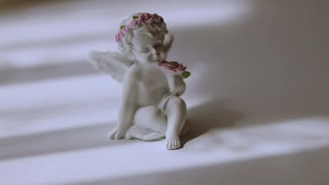 Ceramic angel ornament close-up with window blind shadows Stock Footage 339601252
