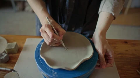 Ceramic Artist Carving Decorative Pattern into Clay Plate with Pottery Loop Tool Stock Footage 319227148