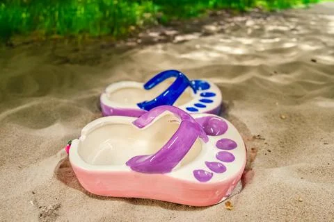Ceramic ashtray in the shape of a flip flop by the sea. Tourism.Vacation Concept Stock Photos