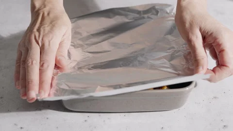 Ceramic baking dish tightly sealed with aluminum foil  Stock Footage 332596550