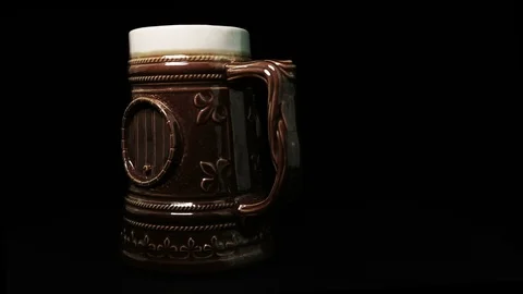 Ceramic beer mug rotates on black background in a loop Stock Footage 86744951