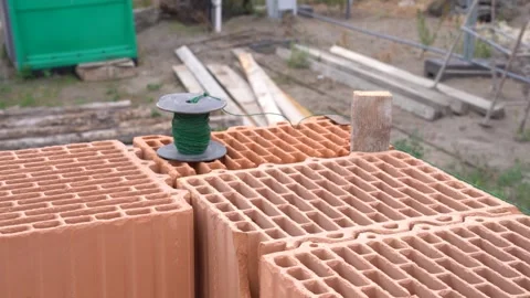 Ceramic blocks stacked with spool of green string and wooden guide on Stock Footage 310549714