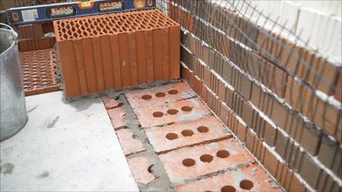 Ceramic blocks. Worker puts a red ceramic block. Building a house from a red  Stock Photos
