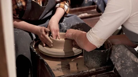 Ceramic bowl making by young lady with help of teacher in pottery workshop Stock Footage 201568537