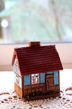 Ceramic candlestick in the shape of a house with a burning candle Stock Photos