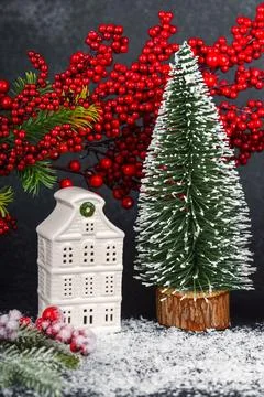 Ceramic Christmas house with pine Tree and winter decorations on black back.. Stock Photos