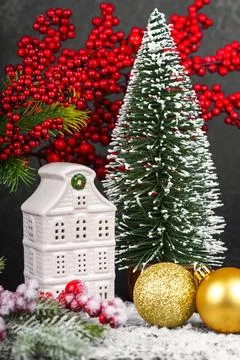 Ceramic Christmas house with pine Tree and winter gold decorations on black.. Foto stock