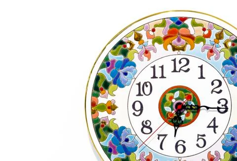 Ceramic clock with bright patterns on a white background. Stock Photos