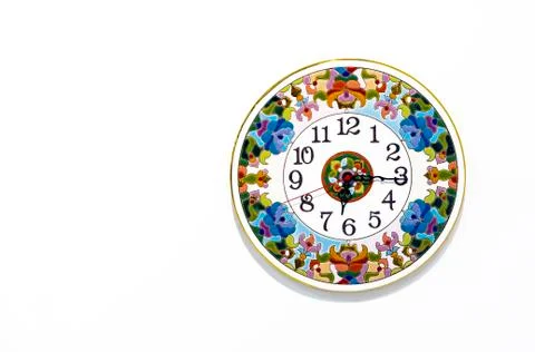 Ceramic clock with bright patterns on a white background. Stock Photos