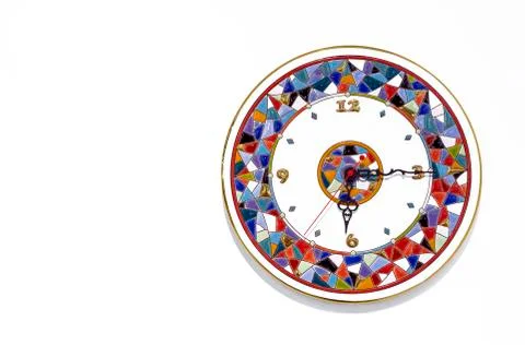 Ceramic clock with bright patterns on a white background. Stock Photos
