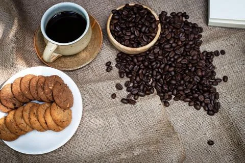 The ceramic coffee cup put at the middle of dish of cookies and coffee beans, Stock Photos