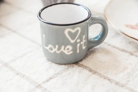 Ceramic coffee mug with "love it" inscription and heart design placed on a Foto stock