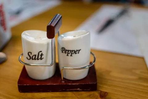 Ceramic container with Salt and pepper on a wood table. Stock Photos