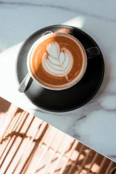 .ceramic cup with cappuccino on a marble table under the sun Stock Photos