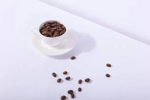 Ceramic cup with coffee beans, on a white background. The harsh shade of the  Stock Photos