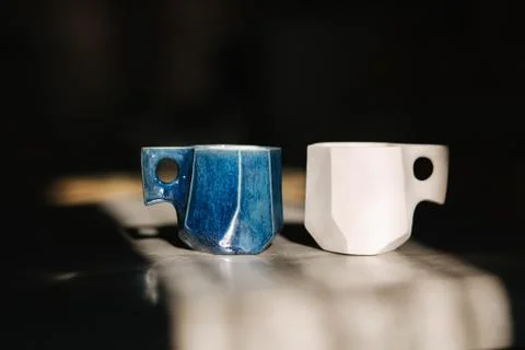 Ceramic cup for coffee on the table. Right is unfinished, left is ready Stock Photos