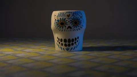 Ceramic cup with floral pattern on dark fabric background. Stock Photos