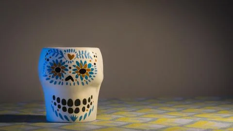 Ceramic cup with floral pattern on dark fabric background. Stock Photos