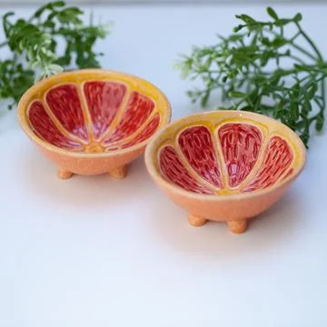 Ceramic cup in the form of half a grapefruit. Stock Photos