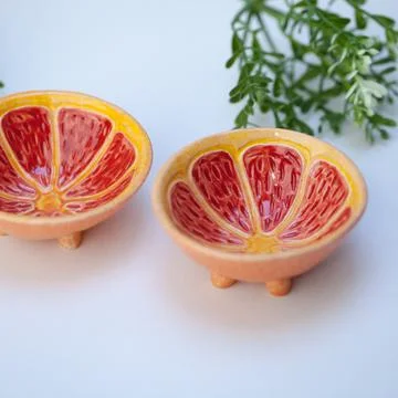 Ceramic cup in the form of half a grapefruit. Stock Photos