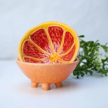 Ceramic cup in the form of half a grapefruit. Stock Photos