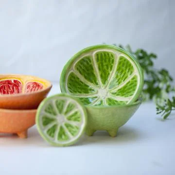 Ceramic cup in the form of half a lime. Stock Photos