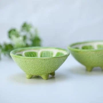 Ceramic cup in the form of half a lime. Stock Photos