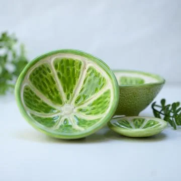 Ceramic cup in the form of half a lime. Stock Photos