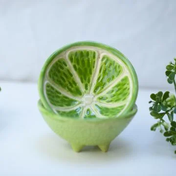 Ceramic cup in the form of half a lime. Stock Photos