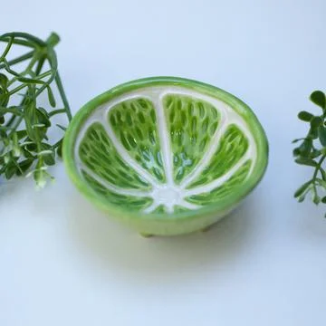 Ceramic cup in the form of half a lime. Stock Photos