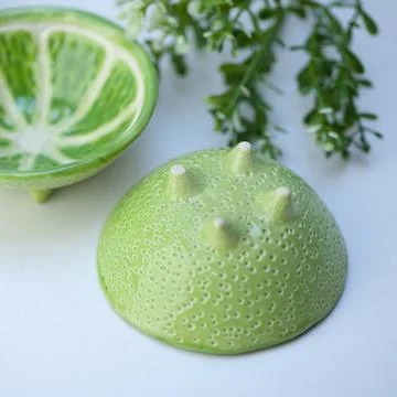 Ceramic cup in the form of half a lime. Stock Photos