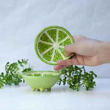 Ceramic cup in the form of half a lime. Stock Photos