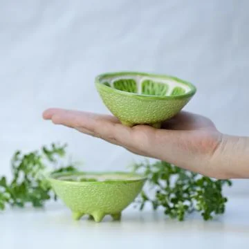 Ceramic cup in the form of half a lime. Stock Photos