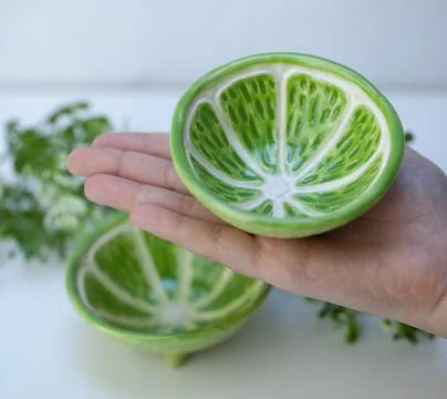 Ceramic cup in the form of half a lime. Stock Photos