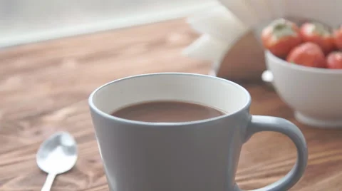 Ceramic cup of hot brown cacao stands on wooden table Stock Footage 68954522