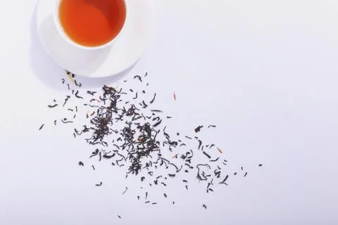 Ceramic cup with tea and tea leaves, on a white background. The harsh shade o Stock Photos