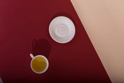 Ceramic cup with tea, on a red background. The harsh shade of the sun, the ar Stock Photos
