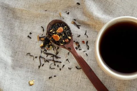 Ceramic cup of tea with scattered tea leaves on a napkin on rustic wooden Stock Photos
