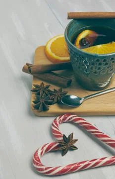 A ceramic cup of warming tea with cinnamon and orange on a rustic white table Stock Photos