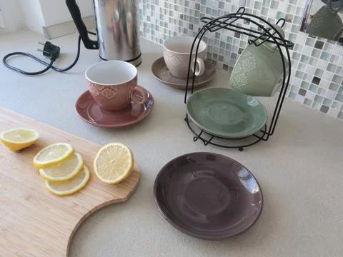 Ceramic cups and sliced lemon on wooden cutting board. Tea and cooking in Stock Photos