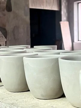 Ceramic cups are carefully crafted from raw clay and prepared for firing in a Stock Photos