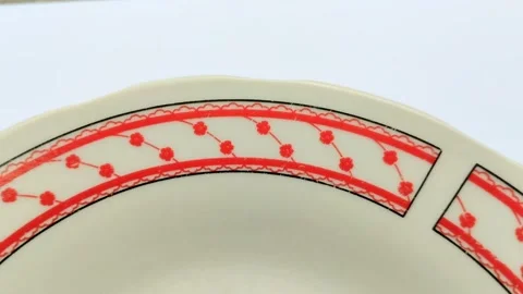 A ceramic dinner plate with a red rose motif on the edge Stock Footage 314931406