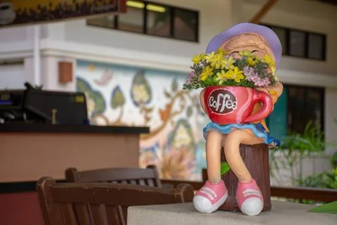 .Ceramic doll holding a coffee cup Stock Photos