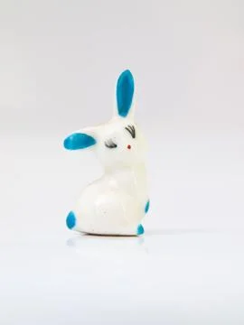 A ceramic doll of white rabbit with light blue spots isolated on white backgr Stock Photos