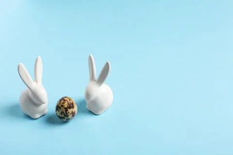 Ceramic Easter bunnies and egg on color background, space for text Foto stock