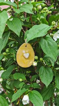 Ceramic Easter egg craft hanging among white blossoms in spring light Stock Photos