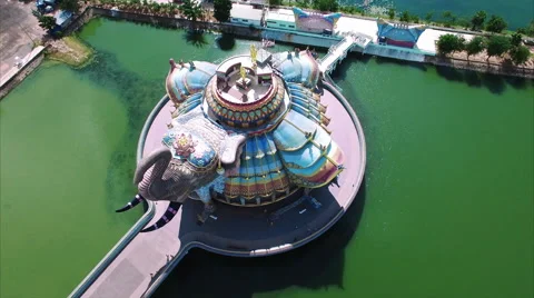 Ceramic elephant temple ringed by green water in Isan Vídeos de archivo 60340028