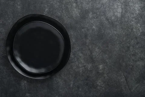 Ceramic empty black plate on old black ceramic cement concrete table backgrou Stock Photos