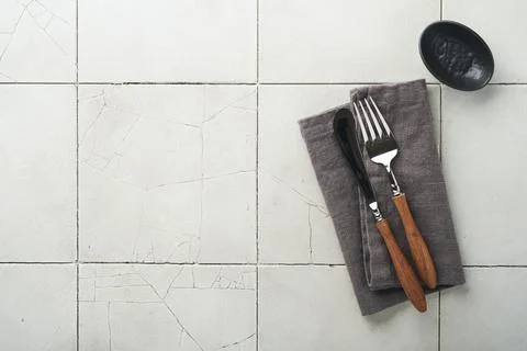 Ceramic empty black plate, silverware and linen kitchen towel napkin on old c Stock Photos